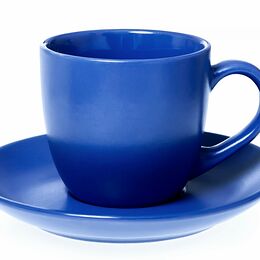 Tazza in ceramica blu con manico, appoggiata sul piattino coordinato dello stesso colore, su fondo bianco.